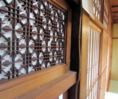 Traditional wooden lattice and shoji screens lining a tatami room interior at Ryokan Taishoro in Nara