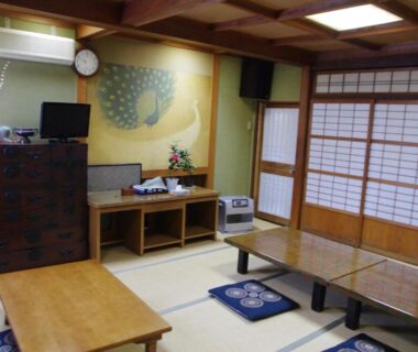 Traditional tatami room with low tables and shoji screens at Ryokan Takayama in Gifu Chūbu