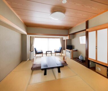 Traditional tatami room with low table, shoji doors and window seating at Ryokan Tamagoyu in Fukushima