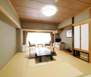Traditional tatami room with low table, shoji doors and window seating at Ryokan Tamagoyu, Fukushima