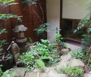 Small courtyard garden with stone lantern, ferns, stepping stones and shoji window at Ryokan Tanabe, Gifu