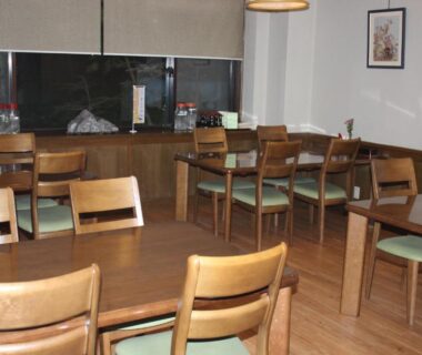 Spacious wooden dining area with tables and chairs at Ryokan Tanaka in Gifu