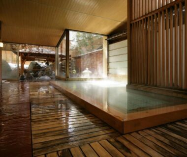Steaming indoor onsen with wooden tub at Ryokan Tanigawa in Gunma
