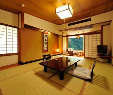 Japanese tatami room with low table, floor chairs, shoji screens and tokonoma at Ryokan Tanigawa in Gunma