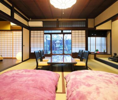 Traditional tatami room with futon bedding, low table and shoji screens overlooking a garden at Ryokan Tanoya Kyoto