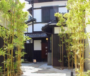 Stone path flanked by bamboo leading to wooden ryokan entrance at Ryokan Tanoya, Kyoto
