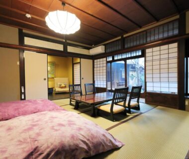 Tatami room with futons, shoji screens and low table at Ryokan Tanoya in Kyoto, Kansai, Japan