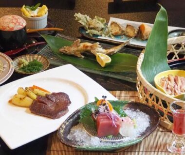 Assorted Japanese multi-course meal with sashimi, grilled meat, soba and small bowls at Ryokan Tenryu in Ōita