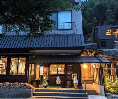 Lit wooden exterior of Ryokan Tenryu with steps and hillside setting in Ōita Kyūshū