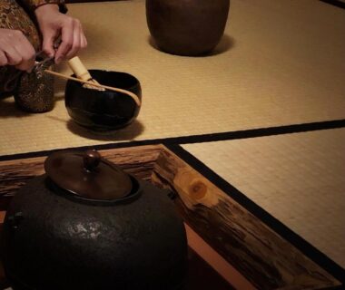 Hands preparing tea over irori hearth in tatami room at Ryokan Tori Kyoto