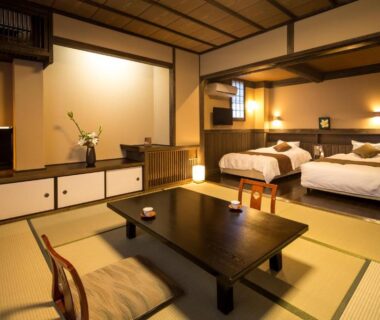 Tatami room with low table and twin beds at Ryokan Wakaba in Kumamoto, Kyūshū