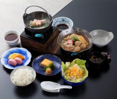 Assorted Japanese breakfast dishes with rice, pickles, salad and simmered pot at Ryokan Wakamiya in Kyoto