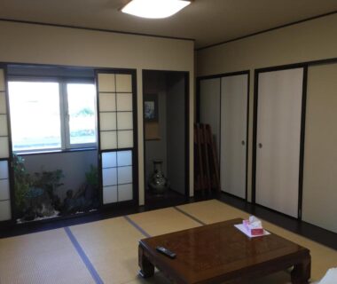 Traditional tatami room with low table, shoji screens, sliding closets and window overlooking garden