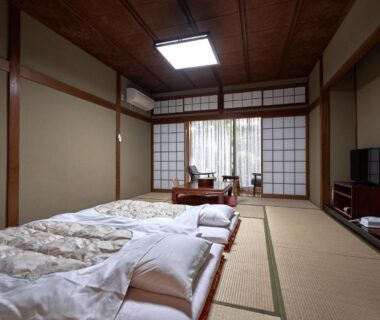 Tatami room with futons and shoji screens at Ryokan Yamamuro in Ishikawa, Chūbu, Japan
