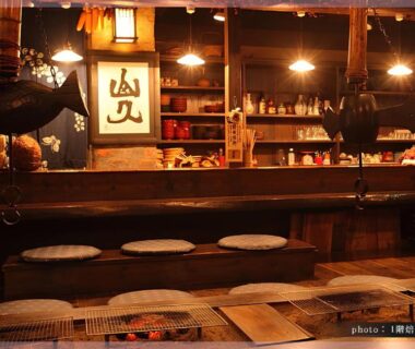 Wooden reception counter with lanterns and floor cushions at Ryokan Yamanoyu in Kumamoto, Kyūshū