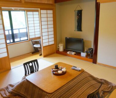 Tatami room with kotatsu table, shoji screens and tokonoma alcove at Ryokan Yamashiroya in Ōita, Kyūshū, Japan