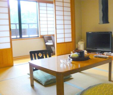 Traditional tatami room with low table and shoji screens at Ryokan Yamashiroya in Ōita, Kyūshū, Japan