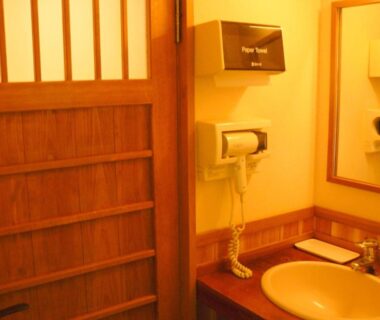Wooden sink, mirror and sliding wooden door in Ryokan Yamashiroya bathroom Ōita Kyūshū