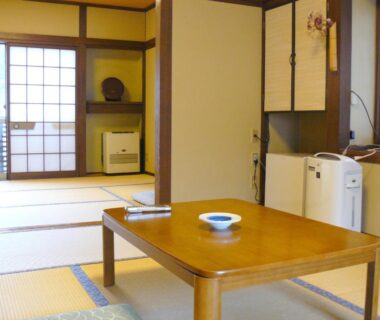 Traditional tatami room with low wooden table and shoji screens at Ryokan Yamashiroya, Ōita, Kyūshū, Japan