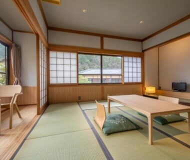 Traditional tatami room with low table, zabuton cushions, shoji screens and large windows at Ryokan Yamazaki Kyoto