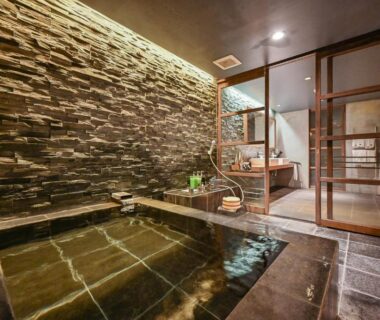 Indoor stone bath with wooden sliding doors and tiled floor at Ryokan Yoshidaya, Saga, Kyushu
