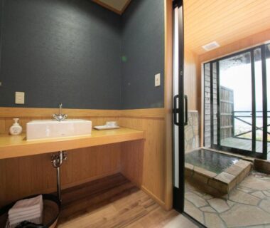 Sink vanity and sliding doors to tiled terrace with wooden soaking tub