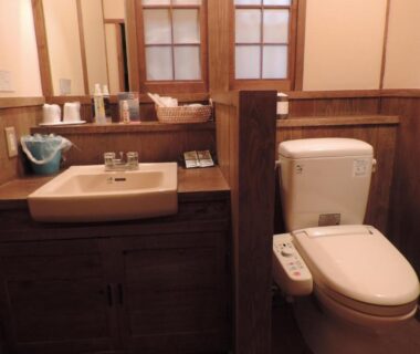 Wooden vanity and bidet toilet with control panel at Ryokan Yunosako in Kumamoto, Kyushu