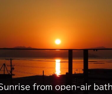 Sunrise over bay viewed from open-air onsen railing at Miyajima-an ryokan in Hiroshima