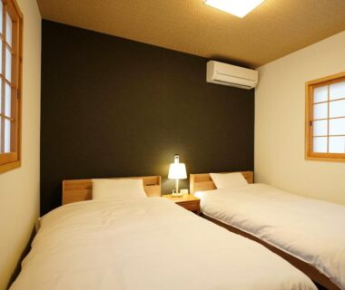 Two single beds with bedside lamp and shoji windows at Ryokoji Temple in Kumamoto, Kyushu