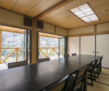 Tatami room with long dining table, sliding doors and balcony at Ryori Ryokan Shikanoyu, Gifu, Chūbu