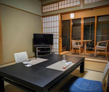 Traditional tatami room with low table, floor cushions, shoji screens and balcony seating at Ryoso Yufuin Yamadaya, Ōita
