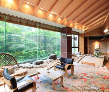 Relaxing lounge with low tables and chairs overlooking a lush inner garden at Ryotei Hanayura, Hokkaido