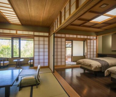 Spacious Japanese-style room with tatami, shoji screens, low table, twin beds and garden view at Ryotei Manyou Ishikawa