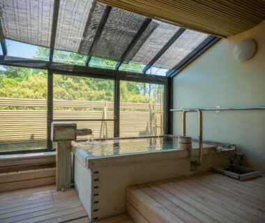 Wooden soaking tub with glass skylight and garden view at Ryotei Manyou, Chūbu, Ishikawa, Japan