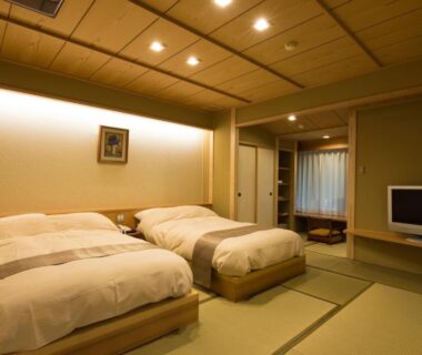 Japanese tatami room with twin beds, shoji doors and low table at Ryotei Manyou, Ishikawa