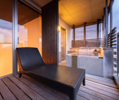 Outdoor soaking tub and lounge on wooden balcony at Ryotei Matsubaya in Ōita, Kyushu