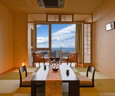 Tatami room with low dining table, shoji screens and sea view at Ryotei Matsubaya in Ōita