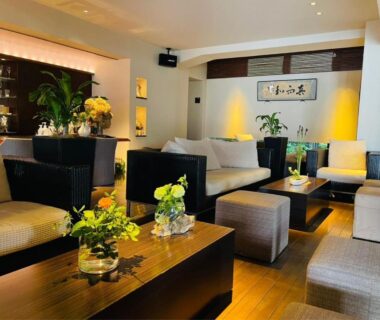 Interior lounge with sofas and low wooden tables at Ryotei Matsuya Honkan Suizenji in Kumamoto Kyūshū