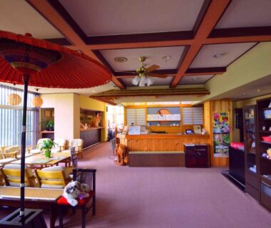 Reception area at Ryoufuso with wooden counter, seating, decorative umbrella and shelves in Mie Japan