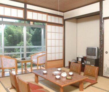 Tatami room with low table, zabuton cushions and shoji screens at Ryoufuso in Mie