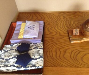 Folded yukata, towels and slippers on wooden surface at Ryounkaku Hokkaidō