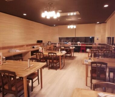 Spacious wooden dining hall with tables and chairs, warm lighting at Ryounkaku in Hokkaido