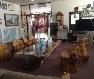 Lobby seating with carved log stools and low glass table at Ryounkaku in Hokkaidō