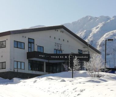 Snow-covered facade and grounds at Ryounkaku in Hokkaidō with mountain peaks in background