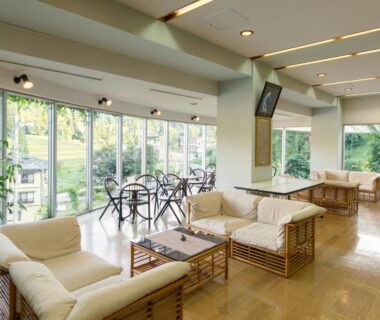 Sunlit lounge with sofas and floor-to-ceiling windows at Ryounkaku Matsunoyama onsen, Niigata