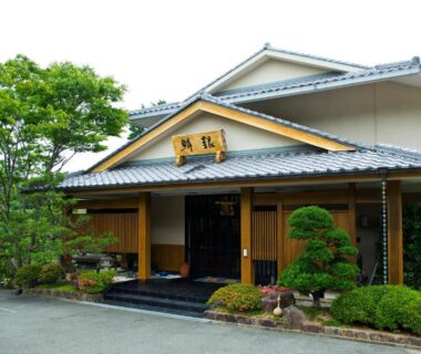 Traditional tiled-roof entrance with wooden sign and manicured shrubs at Ryouri no yado Ginrin, Mie, Kansai