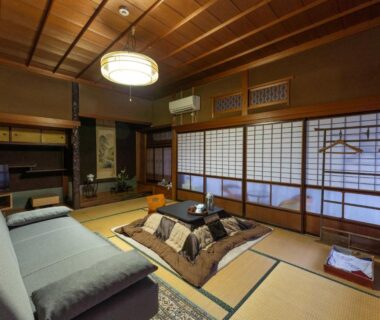 Tatami room with kotatsu, sofa and shoji screens at Ryouriryokan Asahikan in Nara, Kansai