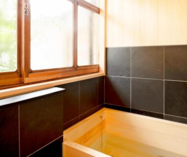 Interior wooden soaking tub by window at Ryouriryokan Asahikan in Nara, Kansai, Japan