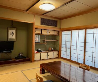 Traditional tatami room with low wooden table, shoji screens and alcove with hanging scroll at Ryujin Onsen Marui Ryokan Wakayama