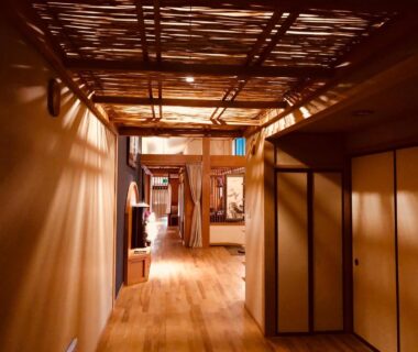 Warm wooden corridor with bamboo lattice ceiling and sliding fusuma doors at Ryutakuzenji, Gunma